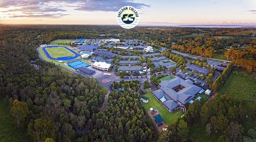 Redlands Rugby Union Club Aerial view of Sheldon College campus featuring buildings, sports fields, parking areas, and surrounding trees under a partly cloudy sky.